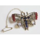A gem set butterfly brooch/pendant, c.1900,with a line of graduated circular mixed cut sapphires