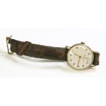 A 9ct gold gentlemen's Cyma mechanical strap watch,with a silvered dial, gilt Arabic numerals and