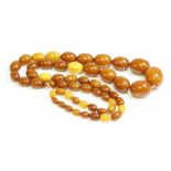 A single row graduated amber bead necklace,with graduated oval brown and honey coloured amber beads,