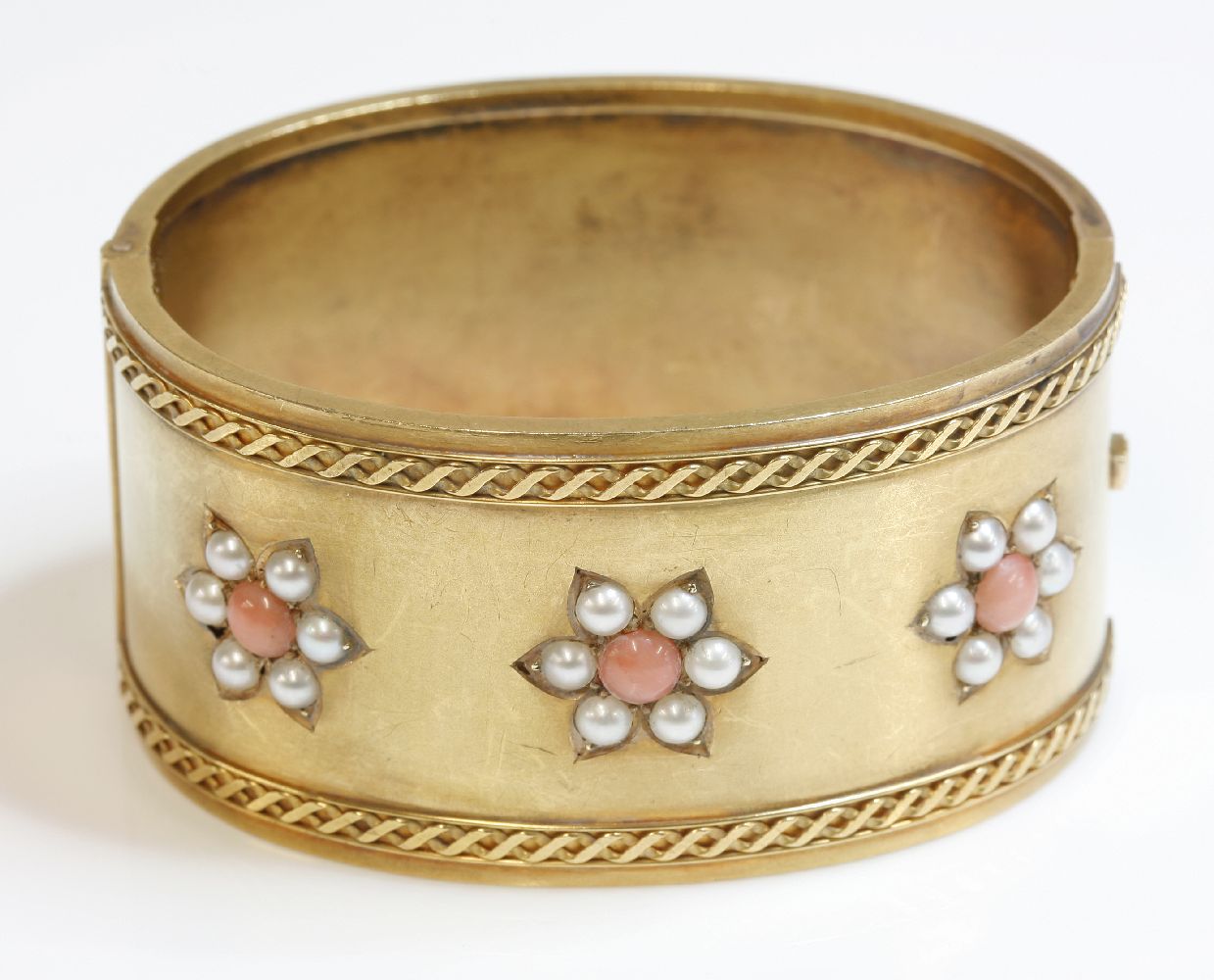 A Victorian coral and split pearl gold hinged bangle,a flat section hinged bangle, 32mm wide, with