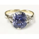 A single stone sapphire ring,with diamond set shoulders.  The slightly cushion shaped oval mixed cut