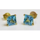 A pair of single stone blue topaz stud earrings,with a square blue topaz, four claw set to post