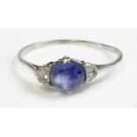 An Art Deco single stone sapphire ring,with diamond set shoulders.  A circular cabochon sapphire