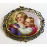 A Victorian gold painted plaque brooch,depicting a male and female couple against grapevines.  The
