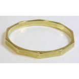A 15ct gold Art Deco slave bangle of decagonal form,with flat section engine turned faces, hand