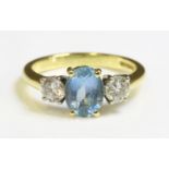 An 18ct gold aquamarine and diamond three stone ring,with an oval mixed cut aquamarine four claw set