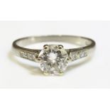 A single stone diamond ring,with diamond set shoulders, with a brilliant cut diamond estimated as