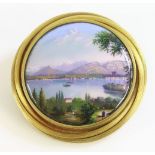 A Swiss cased gold enamel brooch,19th century, depicting a lake and mountain scene.  The circular