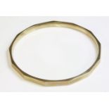 An Art Deco hollow gold slave bangle,with a series of flat section plain faces.  Marked 9ct