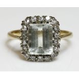 An aquamarine and diamond cluster ring,with a step cut aquamarine four claw set at the corners.  A