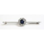 A sapphire and diamond cluster bar brooch, c.1930,with a cushion shaped mixed cut sapphire claw