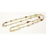 A gold gem set necklace spectacle, set with assorted gemstones to include garnets, peridot, blue