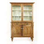 A stripped pine kitchen cupboard, with two glazed doors over two panelled doors, 121cm wide, 200cm