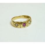 A three stone ruby and split pearl star set gypsy ring, marked 18ct, finger size N½