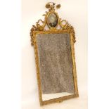 A Continental gilt wood and gesso mirror, central painted glass panel, decorated and surrounded with