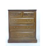 An Edwardian walnut chest of two over three drawers, on plinth base, stamped 'Morris & Co, 449