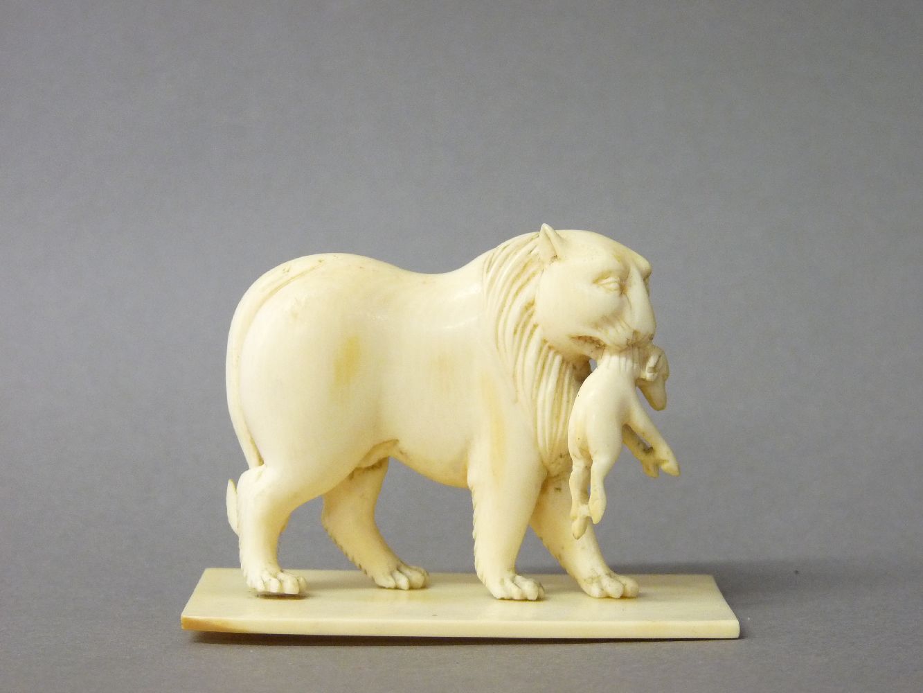 A 19th century ivory figure of a lioness with cub