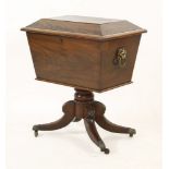 A 19th century mahogany wine cooler, with hinged lion's mask handles, on four sabre legs and brass