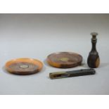 A lignum vitae seal, a pair of lignum vitae circular coasters, an ebony and brass instrument, and