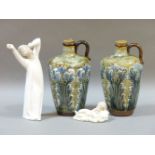 A pair of Royal Doulton stoneware jugs, and two Lladro figures of a sleeping baby and a yawning boy