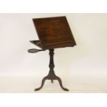 A George III mahogany reading table, with a ratchet top and two candle slides, on a tripod stand
