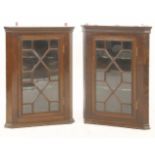 A pair of mahogany hanging corner cabinets, each with a single astragal glazed door, 77cm high