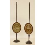 A pair of Regency mahogany pole screens, each panel silk embroidered with baskets of flowers,