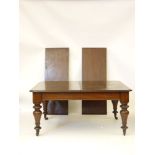 A Victorian mahogany extending dining table, with two extra leaves, on turned legs, raised on