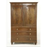 A George III mahogany linen press, with two panelled doors over three long drawers, 130cm wide,