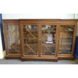 A large early 20th century breakfront display cabinet, with blind fretwork frieze and astragal