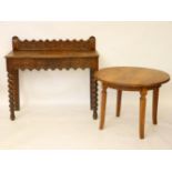 An oak hall table, 105cm wide, with a castellated back, and a walnut circular table, 79cm