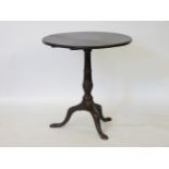 A George III oak tilt top tripod table, the circular top above a turned baluster on cabriole legs,