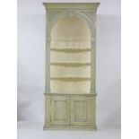 A modern standing corner cabinet, with a barrel back and four open shelves, over two panelled doors,