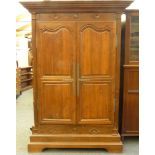 A French walnut armoire, with a heavy oak cornice, over shaped cupboards, 155cm wide, 220cm high