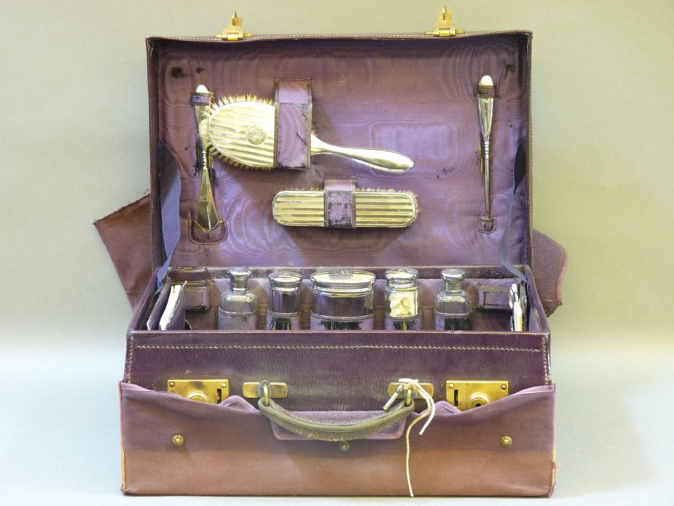 A purple leather dressing case, fitted with silver fittings, incomplete