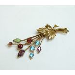 A gold gem set spray brooch, circa 1950, set with blue zircon, garnets and peridot marked 9ct