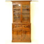A Victorian mahogany bookcase, over a plain glazed cupboard, with horizontal scrolled bars, over