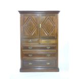 An Edwardian walnut linen press, with moulded cornice above a pair of panelled doors, the base