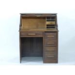 A 1920s oak roll top single pedestal desk