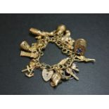 A 9ct gold charm bracelet, with a collection of 9ct gold charms, including a kettle and dolphin