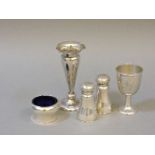 An Indian silver three piece cruet set, a spill vase, and an egg cup