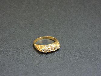 An 18ct gold five stone diamond carved head ring