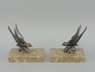 A pair of Art Deco 'swallow' bookends, on marble plinths