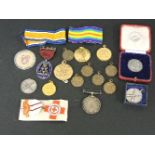 A collection of medals and badges, including two WWI British medals, War medal 422184 Pte HS Bush