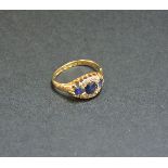 An 18ct gold three stone sapphire and diamond cluster ring, Birmingham 1901