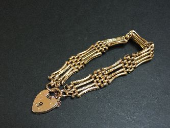 An Edwardian four row gold gate bracelet, marked 9ct