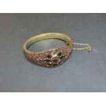 A Bohemian garnet gilt metal bangle, with a central star, some stones deficient