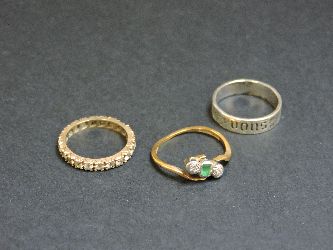 A gold synthetic spinel full eternity ring, marked 9ct, an emerald and diamond three stone ring