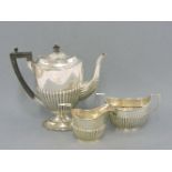 A matched silver three piece coffee set, with part reeded body, mixed dates and makers, 29oz