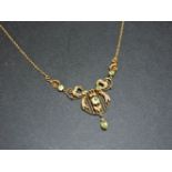 An Edwardian peridot and split pearl necklace, with a centrepiece of a circle with blade edge